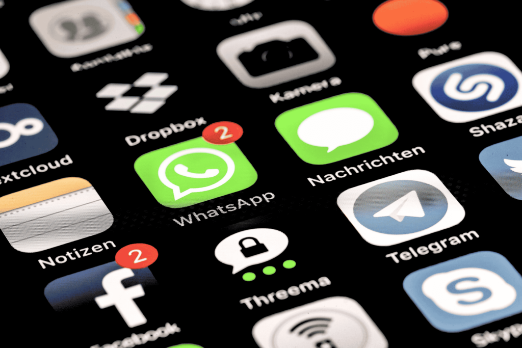 Ein modernes Handydisplay, das die Symbole und Logos der besten Messenger-Apps zeigt. Die Apps umfassen WhatsApp, Threema, Telegram und iMessage.